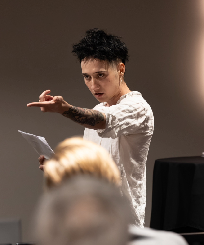 Apollo Chastain gesturing while reading from a sheet of paper